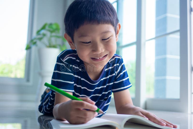 The boys enjoy reading and writing books. Children smile and relax in the living room in the house