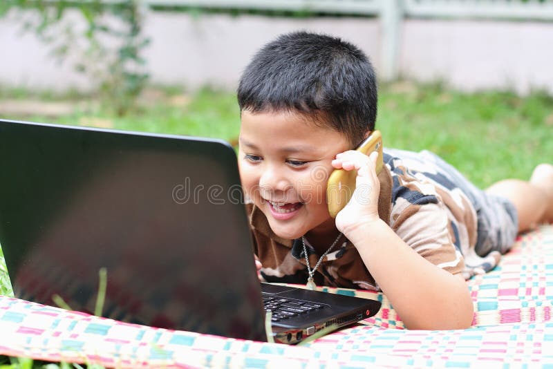 The boys are playing a laptop stock photo The boys are playing a laptop stock photo
