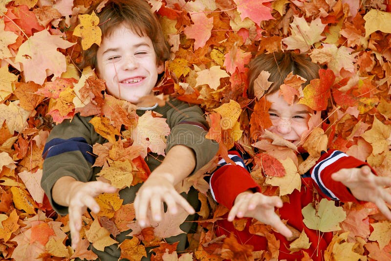 Boys Playing Throwing the Fall Leaves Up in the Air. Boys Playing Throwing the Fall Leaves Up in the Air