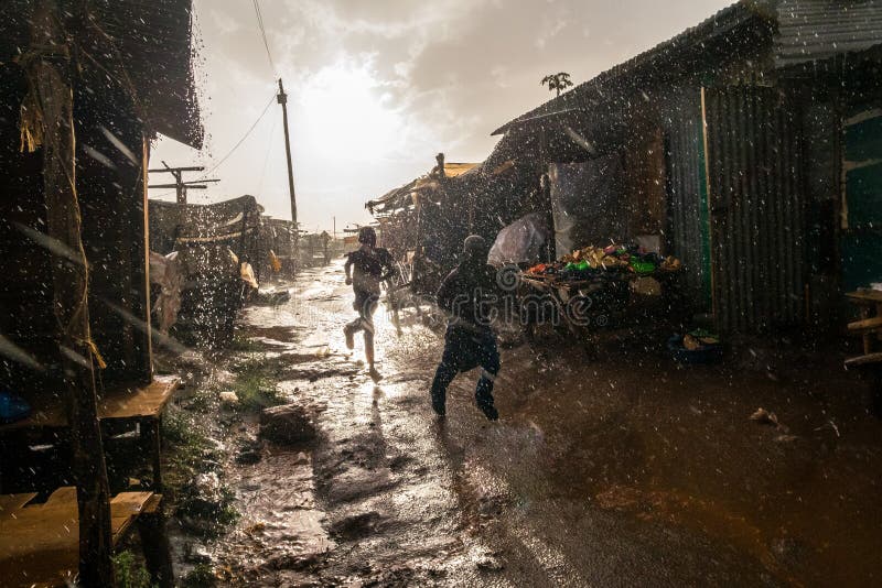 Boys running through african market during rain royalty free stock photos Boys running through african market during rain royalty free stock photos