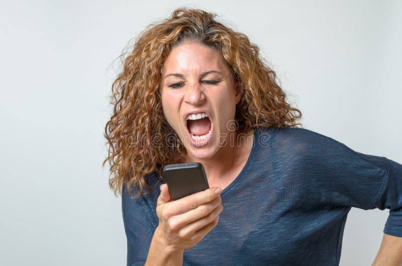 Boze jonge vrouw die bij mobiel haar schreeuwen royalty-vrije stock fotografie Boze jonge vrouw die bij mobiel haar schreeuwen royalty-vrije stock fotografie