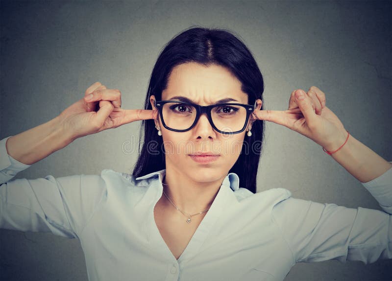Boze vrouw die haar die oren met vingers stoppen door iemand worden geërgerd stock afbeelding Boze vrouw die haar die oren met vingers stoppen door iemand worden geërgerd stock afbeelding