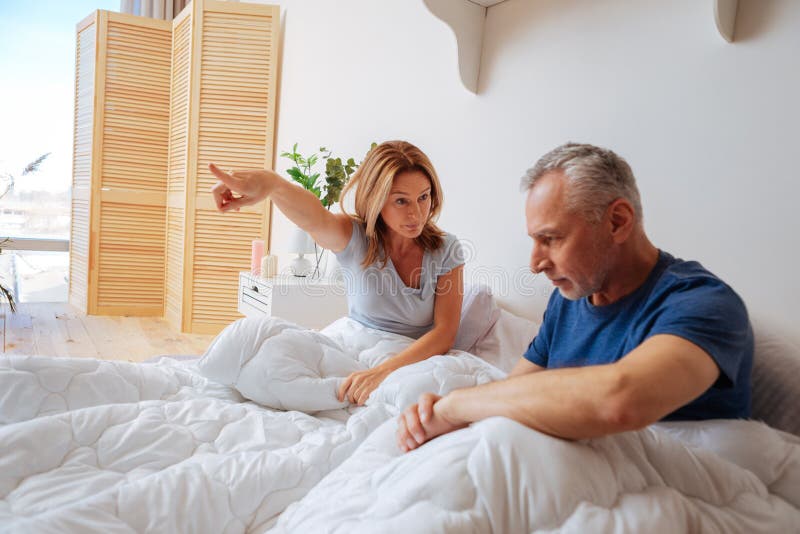 Boze vrouw die haar echtgenoot vragen om vanaf de slaapkamer te gaan stock foto Boze vrouw die haar echtgenoot vragen om vanaf de slaapkamer te gaan stock foto
