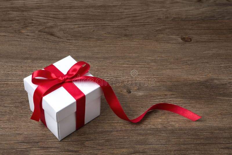 Boîte-cadeau avec l'arc rouge sur la table rustique, un Noël ou une célébration différente photos stock