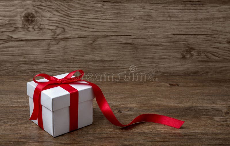 Boîte-cadeau avec l'arc rouge sur la table rustique, un Noël ou une célébration différente photo stock