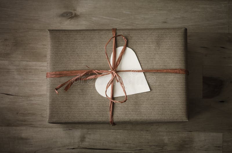 Boîte-cadeau avec l'emballage simple et le label en forme de coeur photographie stock Boîte-cadeau avec l'emballage simple et le label en forme de coeur photographie stock