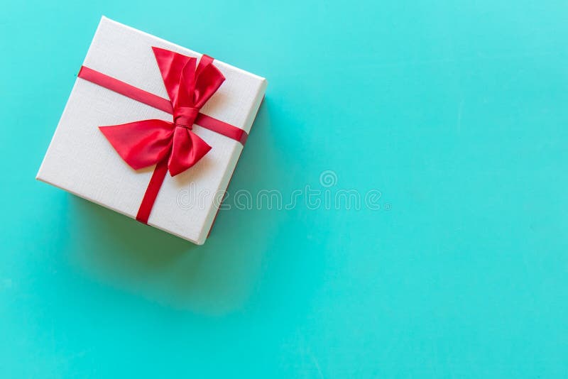 Boîte-cadeau blanc de jour de Valentine’s avec un arc rouge sur le plein fond de mur de couleur, l'espace de copie image stock Boîte-cadeau blanc de jour de Valentine’s avec un arc rouge sur le plein fond de mur de couleur, l'espace de copie image stock