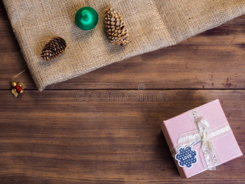 Boîte-cadeau de vintage, cônes de sapin, jouet de Noël, ruban avec l'arc sur le bois et fond de toile de jute, vue supérieure de photo libre de droits Boîte-cadeau de vintage, cônes de sapin, jouet de Noël, ruban avec l'arc sur le bois et fond de toile de jute, vue supérieure de photo libre de droits