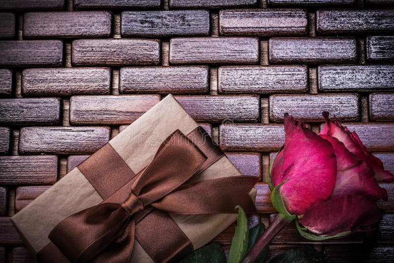 Boîte-cadeau enveloppé par rose parfumée rouge sur l'osier image libre de droits