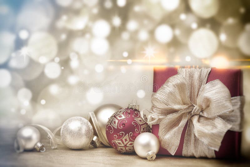 Boîte-cadeau et babioles rouges de Noël sur le fond des lumières d'or defocused