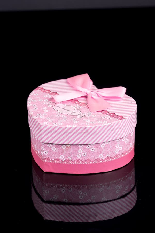Boîte en forme de coeur rose au-dessus de fond noir avec des réflexions photos libres de droits Boîte en forme de coeur rose au-dessus de fond noir avec des réflexions photos libres de droits
