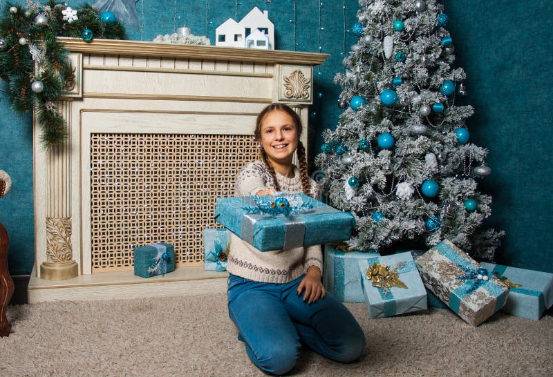 Boîte heureuse de cadeau de Noël de prise de fille le matin de vacances dans le bel intérieur de chambre Enfant féminin presque t images stock Boîte heureuse de cadeau de Noël de prise de fille le matin de vacances dans le bel intérieur de chambre Enfant féminin presque t images stock