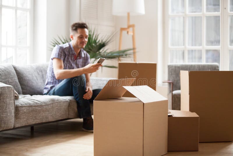 Boîtes en carton emballées avec l'homme appelle le service de distribution, se déplaçant image libre de droits Boîtes en carton emballées avec l'homme appelle le service de distribution, se déplaçant image libre de droits