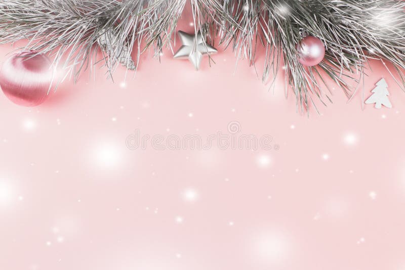 Boże Narodzenia graniczą z jedlinowymi gałąź, boże narodzenie piłkami i srebro ornamentami na pastelowych menchii tle, śnieżny sp