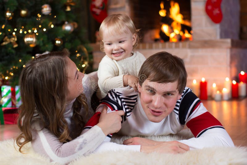 Boże Narodzenia, mas, rodzina, ludzie, szczęścia pojęcie - szczęśliwi rodzice bawić się z ładnym dzieckiem