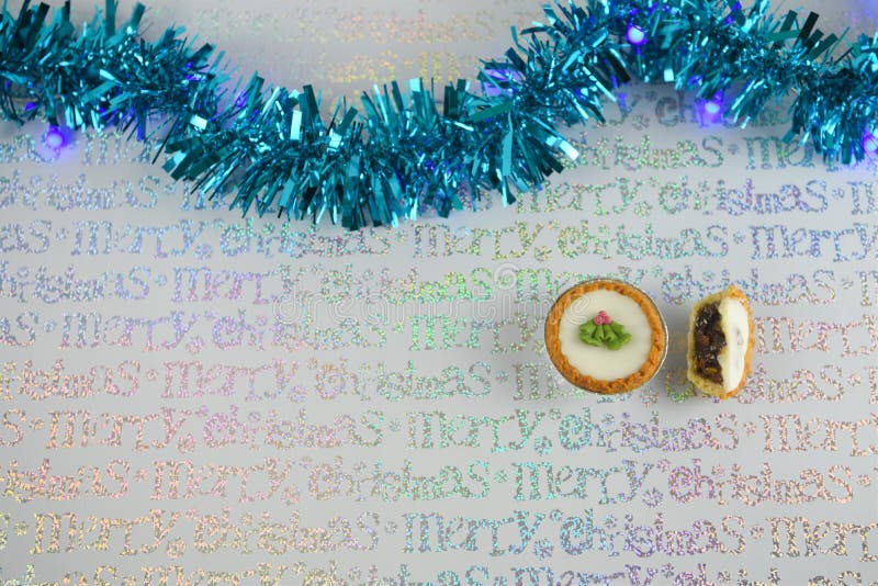 Bożenarodzeniowy fotografia wizerunek xmas karmowi mince pie z błękitnym świecidełkiem i lekkim opakunkowego papieru tłem zdjęcia stock Bożenarodzeniowy fotografia wizerunek xmas karmowi mince pie z błękitnym świecidełkiem i lekkim opakunkowego papieru tłem zdjęcia stock