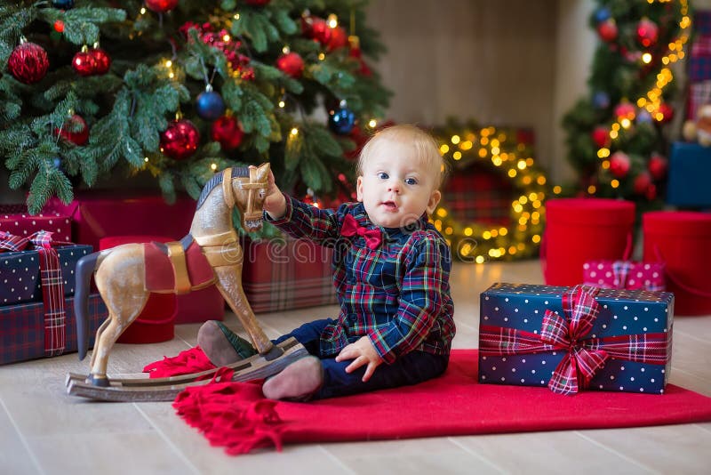 Bożenarodzeniowy portret śliczna mała nowonarodzona chłopiec, ubierający w bożych narodzeń ubraniach i być ubranym Santa kapelusz zdjęcia stock Bożenarodzeniowy portret śliczna mała nowonarodzona chłopiec, ubierający w bożych narodzeń ubraniach i być ubranym Santa kapelusz zdjęcia stock