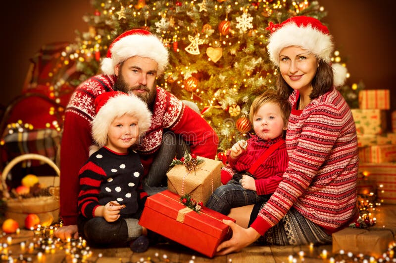 Bożenarodzeniowy rodzina przód Xmas drzewa prezenta Otwarty Teraźniejszy pudełko, ojca Macierzysty dziecko i dziecko w Czerwonym zdjęcia royalty free Bożenarodzeniowy rodzina przód Xmas drzewa prezenta Otwarty Teraźniejszy pudełko, ojca Macierzysty dziecko i dziecko w Czerwonym zdjęcia royalty free