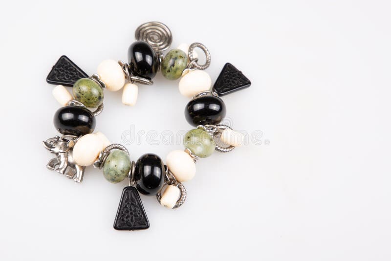 Bracelet perlé fait main avec les boules blanches et vertes noires de pierres sur le fond blanc images stock Bracelet perlé fait main avec les boules blanches et vertes noires de pierres sur le fond blanc images stock