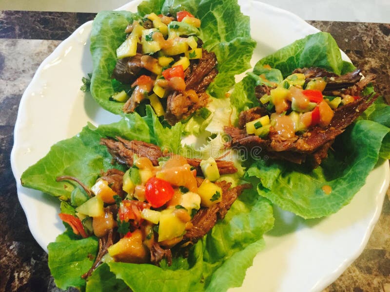 Braised short rib with peanut sauce and mango salsa stock images