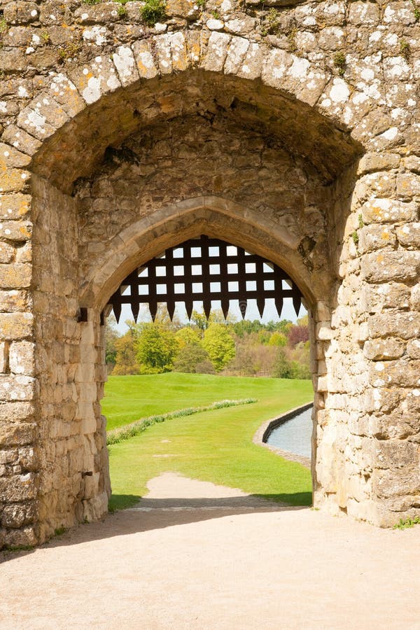 Detail of medieval stone castle gate, with grass and mote in the background. Detail of medieval stone castle gate, with grass and mote in the background