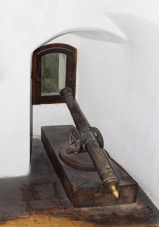 A small gun is standing in a niche by the window in the Bran Castle. Bran city in Romania