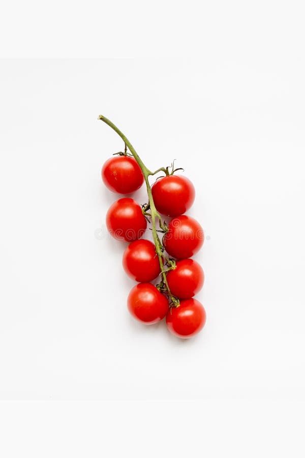Branch of fresh cherry tomatoes on a white background