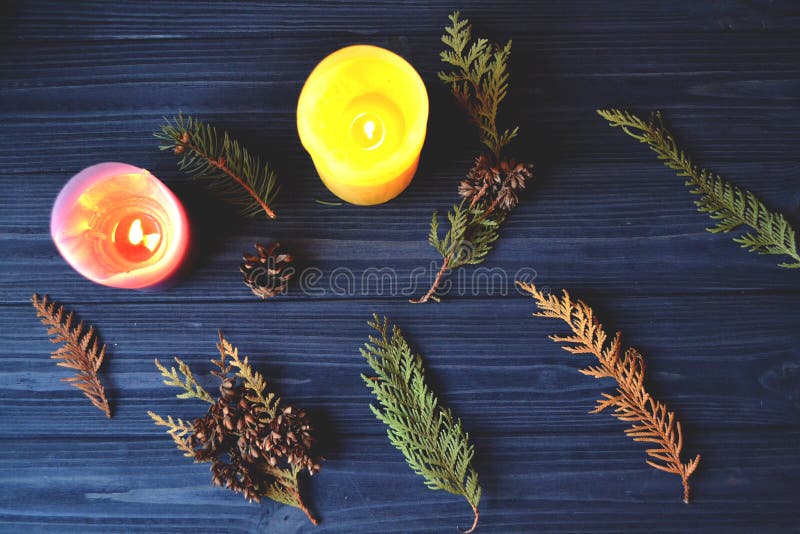 The branches of fir-tree on the dark blue wooden background. Natural pattern with candles. Atmospheric photo. stock photos The branches of fir-tree on the dark blue wooden background. Natural pattern with candles. Atmospheric photo. stock photos
