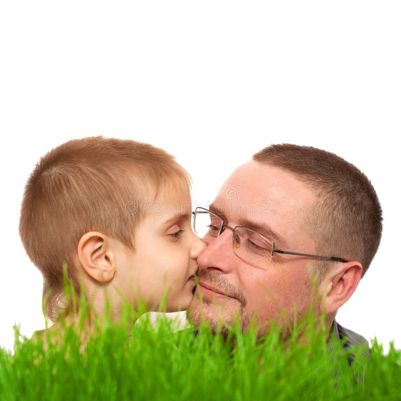 Branco da grama verde de dia de pai do beijo da criança do pai imagem de stock royalty free