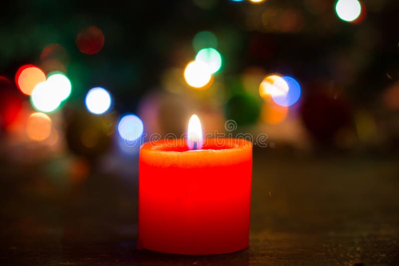 Brand van eenzame rode kaars op Kerstmisachtergrond stock fotografie Brand van eenzame rode kaars op Kerstmisachtergrond stock fotografie