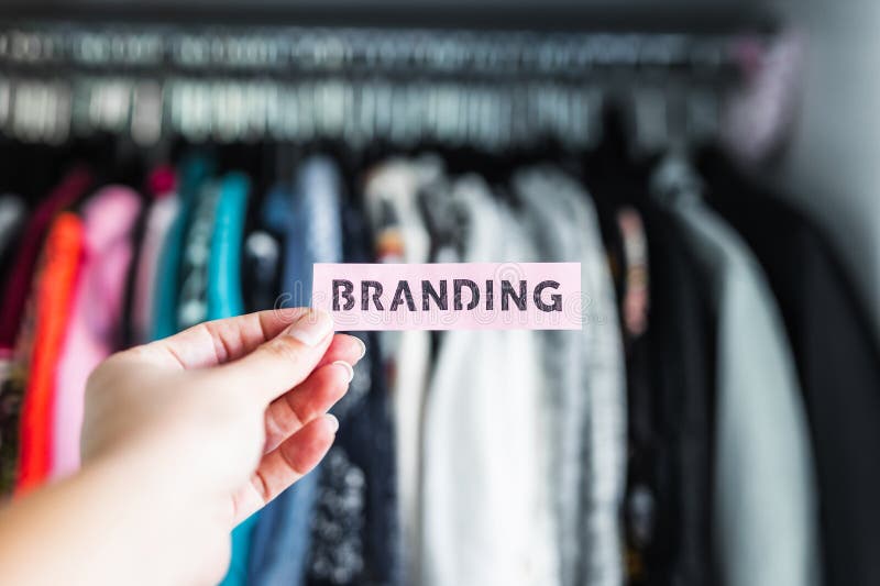 Fashion brands and competition, Branding sign held in front of wardrobe full of clothes royalty free stock images Fashion brands and competition, Branding sign held in front of wardrobe full of clothes royalty free stock images