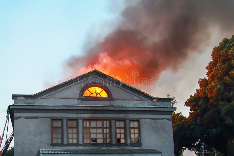 Brandmän på taket av ett hus som är på brand fotografering för bildbyråer Brandmän på taket av ett hus som är på brand fotografering för bildbyråer