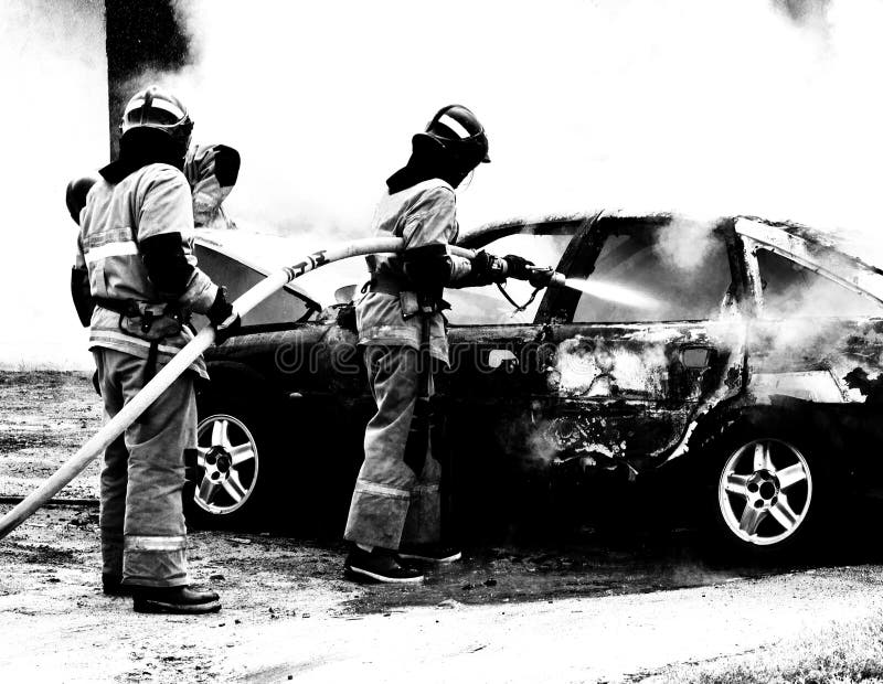 Brandmän släcker en brinnande bil, brand och bil som är svartvita arkivfoto Brandmän släcker en brinnande bil, brand och bil som är svartvita arkivfoto