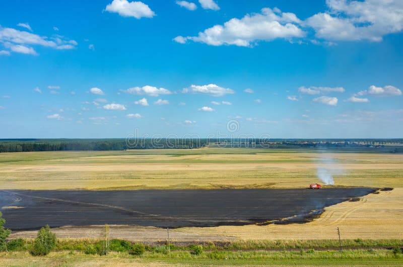 Brandweermanvrachtwagen die aan het gebied op brand werken stock foto Brandweermanvrachtwagen die aan het gebied op brand werken stock foto