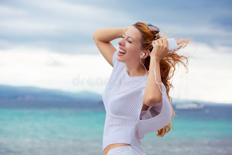 Bras heureux de femme en air appréciant la danse de nature en écoutant le fond de la mer d'extérieur de musique image stock