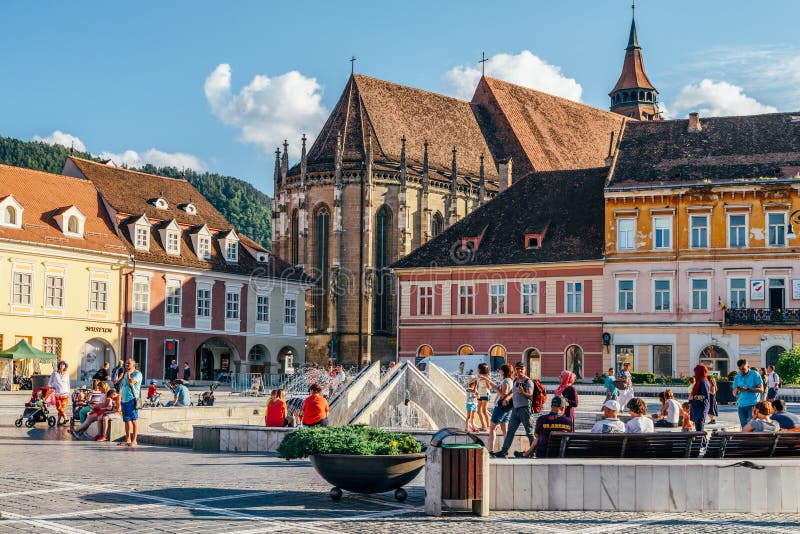 Brasov Council Square with Black Church in the background, surrounded by colorful buildings.