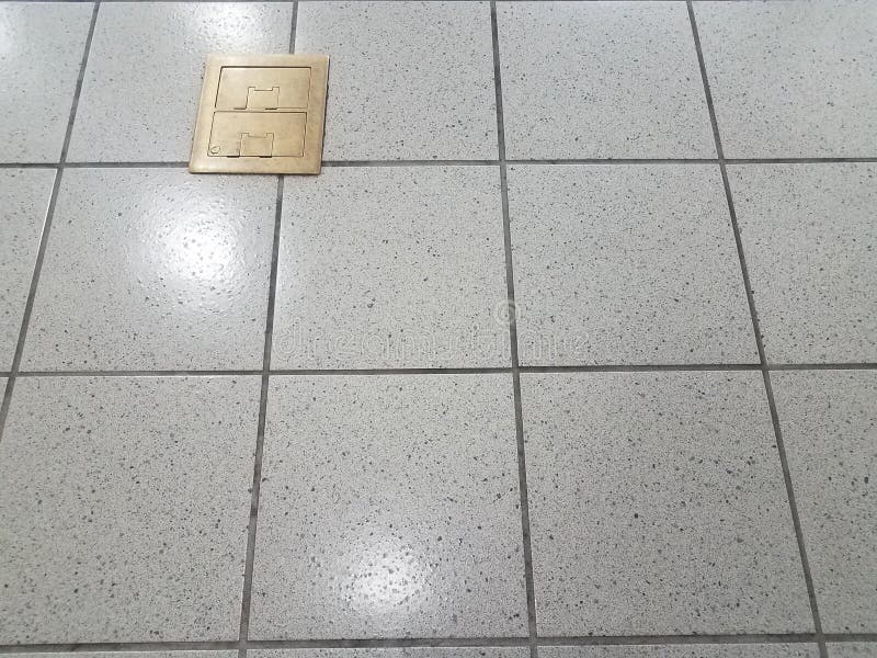 Brass Metal Electrical Outlets On Grey Tile Floor Stock Photo