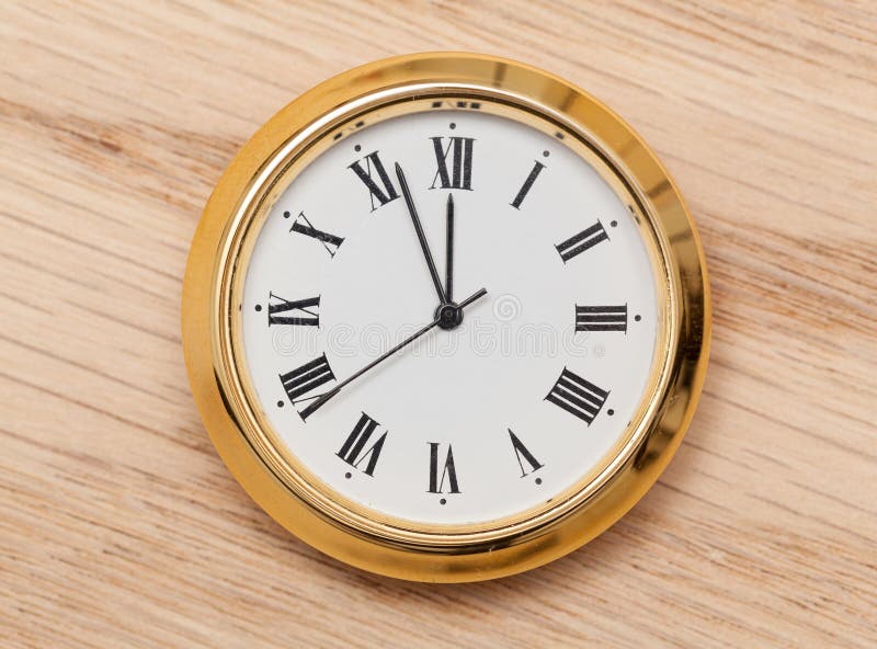 Brass small watch or clock on wood table royalty free stock photography