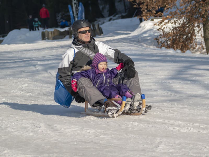 Braunlage, Niemcy - 15 Februar 2015: Zima sporty wakacyjni dla rodziny Dziad i dziecko iść saneczkować Zimy rodziny sporty zdjęcia royalty free Braunlage, Niemcy - 15 Februar 2015: Zima sporty wakacyjni dla rodziny Dziad i dziecko iść saneczkować Zimy rodziny sporty zdjęcia royalty free