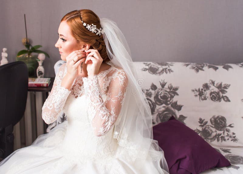 Braut nimmt die Ohrringe und heiratet Vorbereitung lizenzfreie stockfotografie Braut nimmt die Ohrringe und heiratet Vorbereitung lizenzfreie stockfotografie