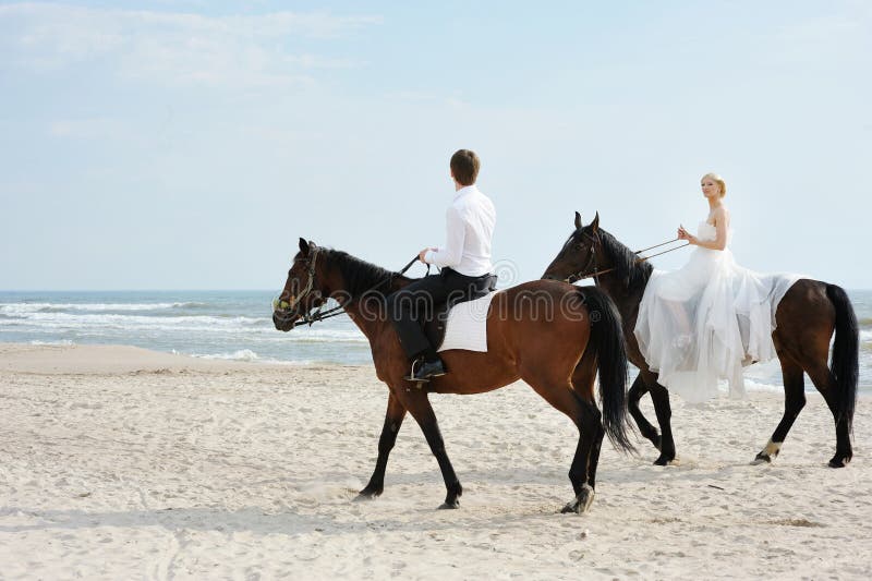Braut und Bräutigam auf Pferde durch das Meer stockfotos Braut und Bräutigam auf Pferde durch das Meer stockfotos