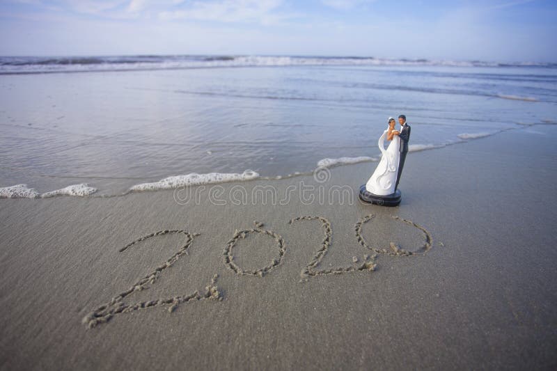 Braut und Bräutigam Figurine am Strand mit dem Jahr 2020 geschrieben in den Sand stockbilder Braut und Bräutigam Figurine am Strand mit dem Jahr 2020 geschrieben in den Sand stockbilder