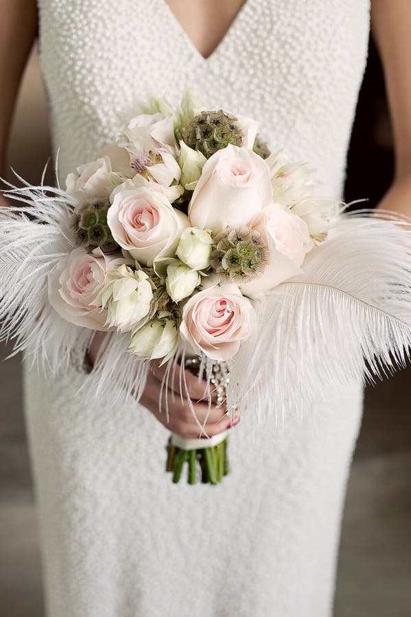 Brautholdingblumenstrauß der Rosen mit Federn stockfoto Brautholdingblumenstrauß der Rosen mit Federn stockfoto