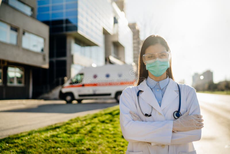 Brave coronavirus paramedic in front of isolation hospital facility.Covid-19 emergency room doctor with protective glasses / mask