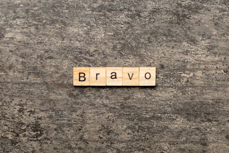 BRAVO Word Written on Wood Block. BRAVO Text on Cement Table for Your