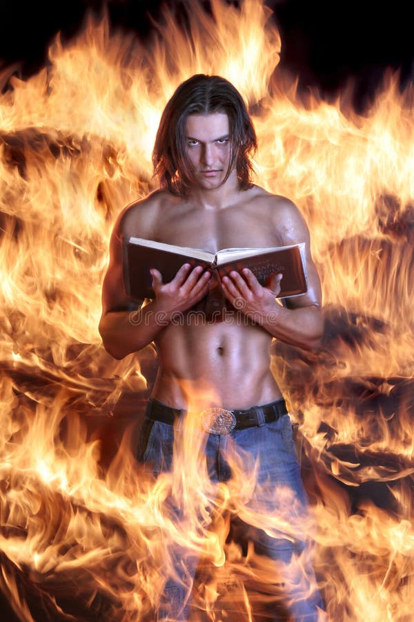 Brawny l'uomo tiene il libro e brucia su fuoco fotografia stock Brawny l'uomo tiene il libro e brucia su fuoco fotografia stock