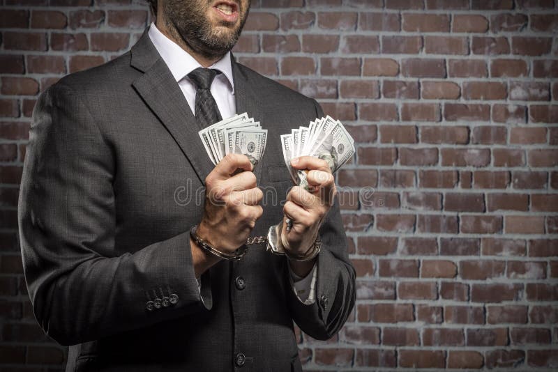 Corrupt man holding bills of money. Brazilian man holding bills of money with a handcuff in a jail. concept of corruption, corrupt politicians, illegal royalty free stock images Corrupt man holding bills of money. Brazilian man holding bills of money with a handcuff in a jail. concept of corruption, corrupt politicians, illegal royalty free stock images