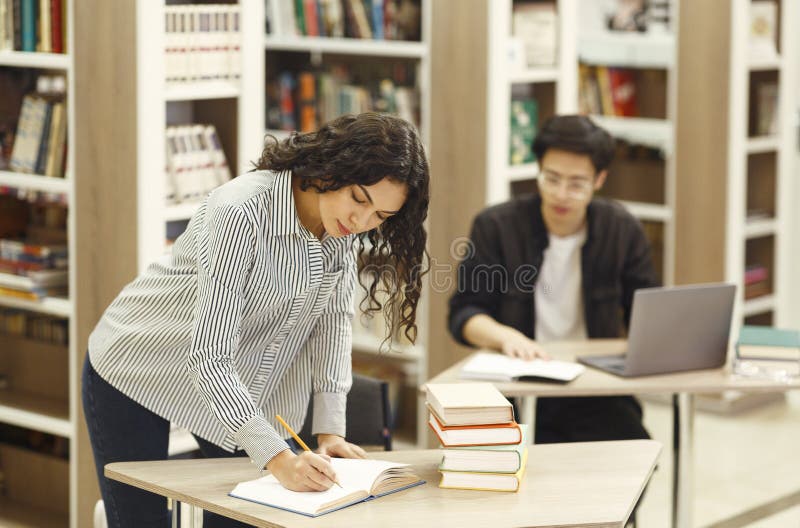 Brazilian professor taking some notes in library