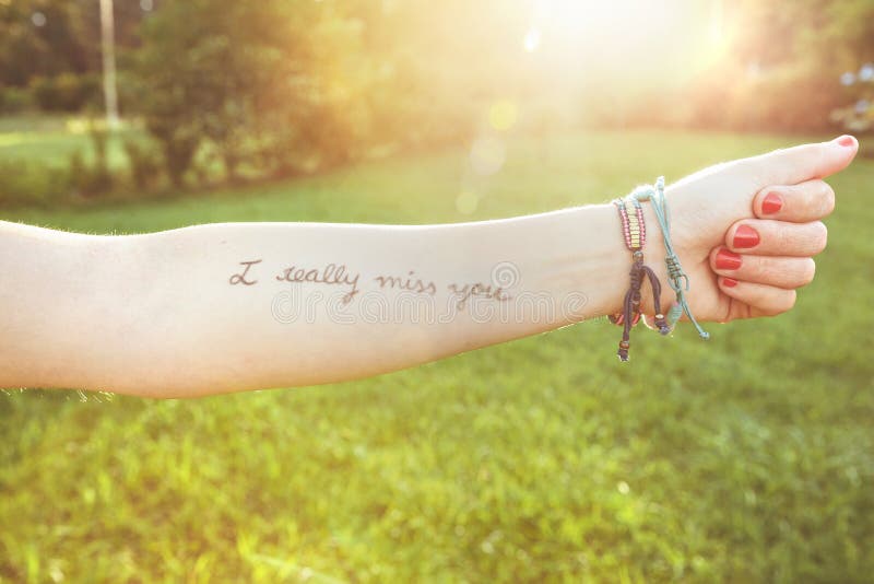 Brazo femenino con el texto - le falto realmente escrito imagen de archivo libre de regalías Brazo femenino con el texto - le falto realmente escrito imagen de archivo libre de regalías