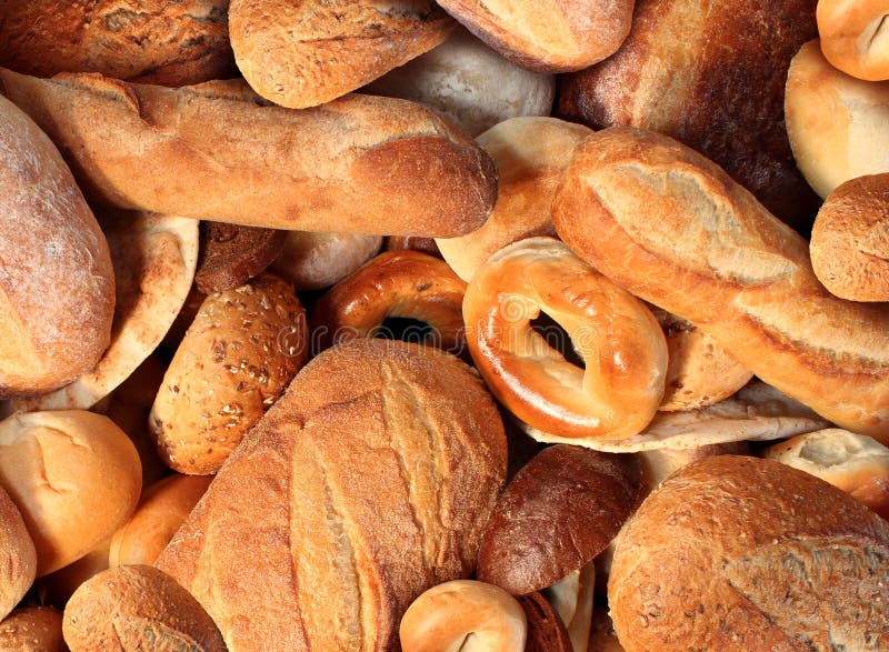 Bread background staple food concept with a group of baked goods from a bakery or home cooking made from whole wheat and grains with breads as pumpernickel pita bagel made from dough.